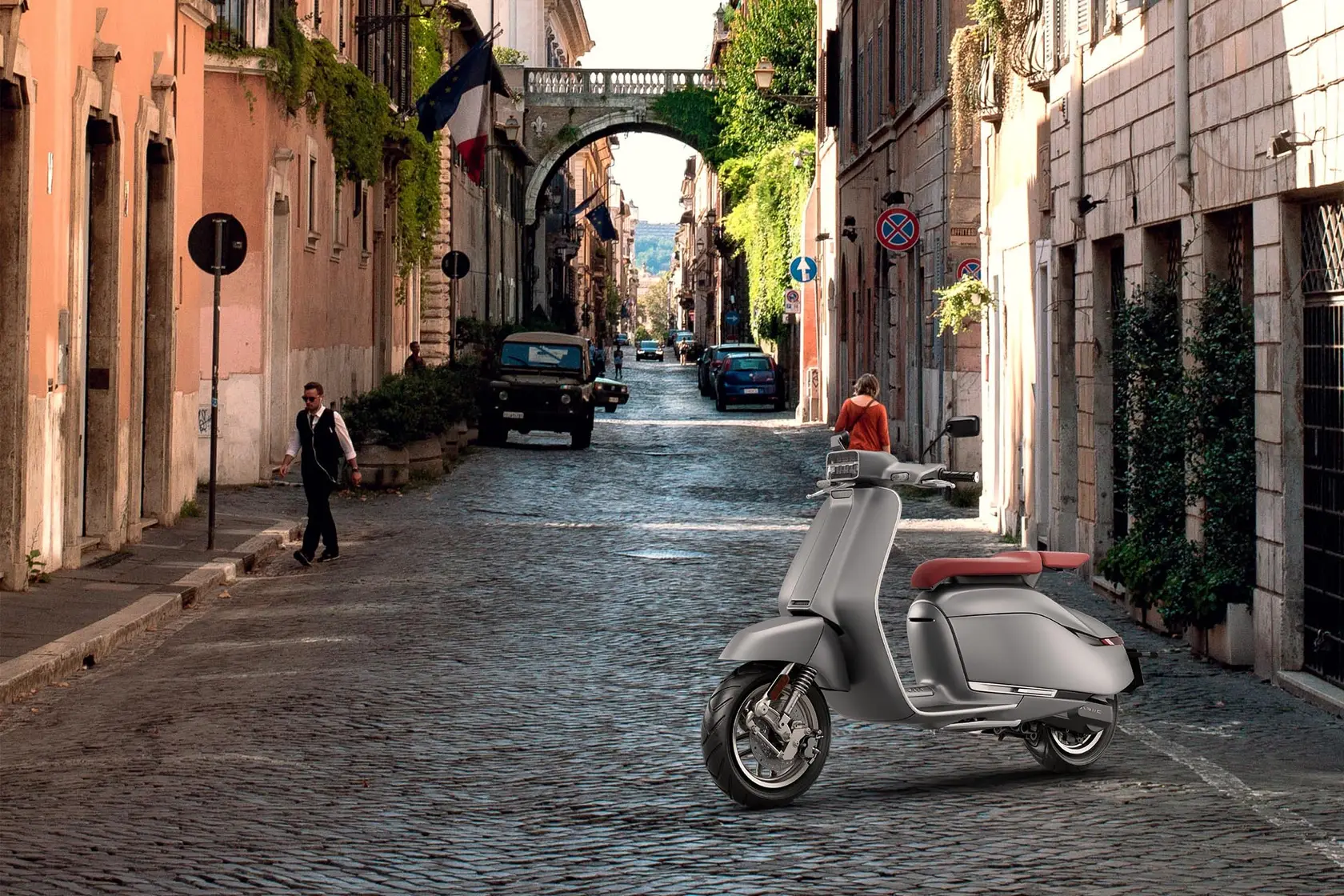 Brio II on a cobbled street with an ivy-covered arch in the distance