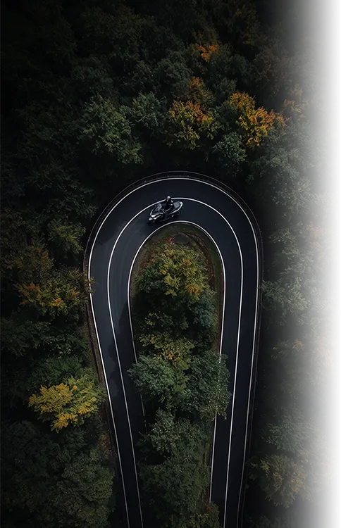 Aerial view of a hairpin road through a forest